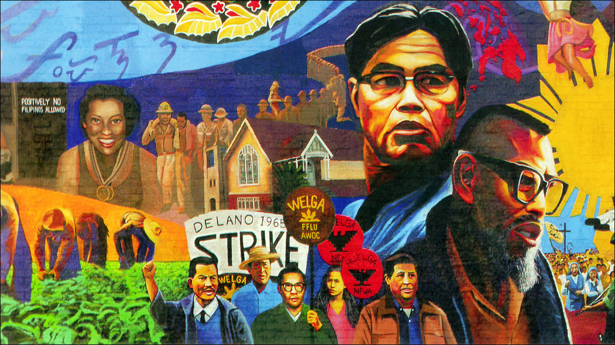 Image Description: This colorful detail from a mural in Los Angeles' Filipinotown shows Philip Vera Cruz and Larry Itliong. Underneath them, people hold signs at a strike. To their left are people working in the fields. To their right is the star from the flag of the Philippines. 
